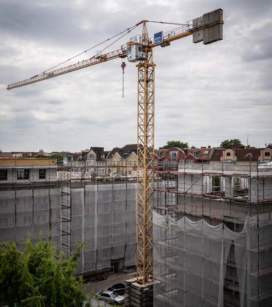 Turmdrehkran mit danbau-Fahne über einer Berliner Baustelle